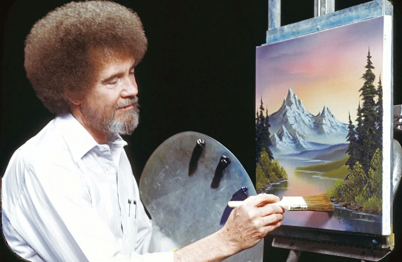 Bob Ross painting a mountain landscape on The Joy of Painting