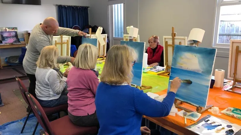 Students at easels in a Bob Ross style painting class, a tradition that began with television painters