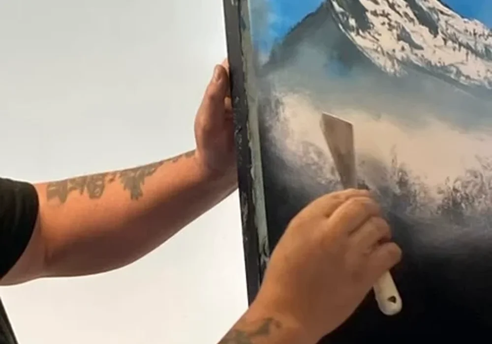 Bob Ross certified instructor Mark Terrell painting snow-capped mountains with a palette knife