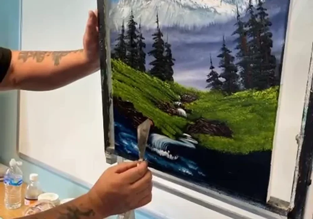 Mark Terrell painting a Bob Ross style snowy mountain with pine trees at oil painting class in Kent