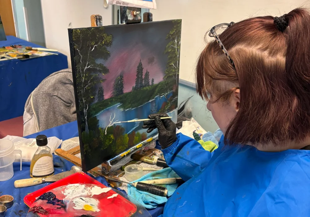 Oil painting class for adults in Kent Adult student painting a Bob Ross landscape at an oil painting class in Kent